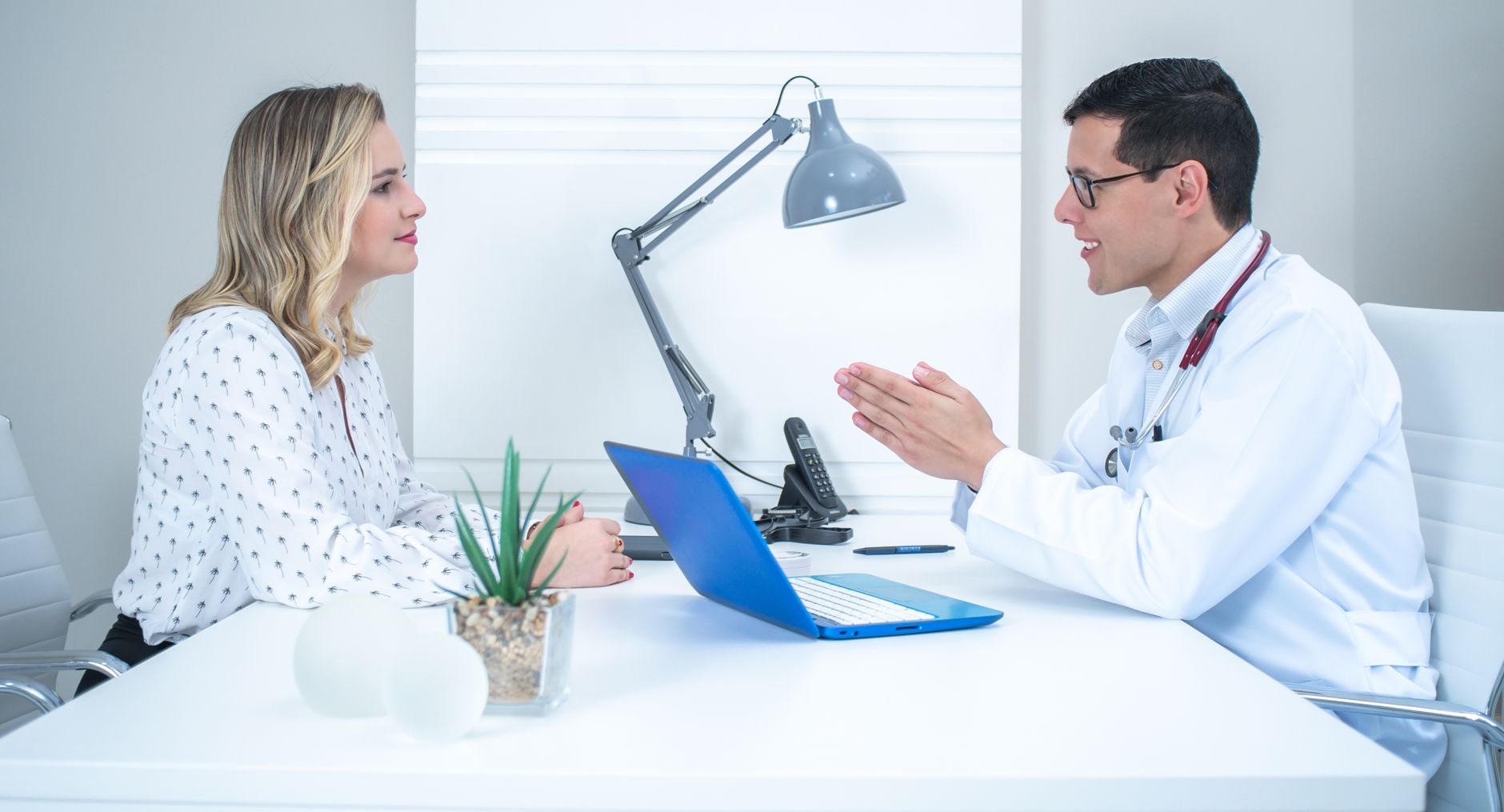 A clinician talking a patient through her treatment at a desk