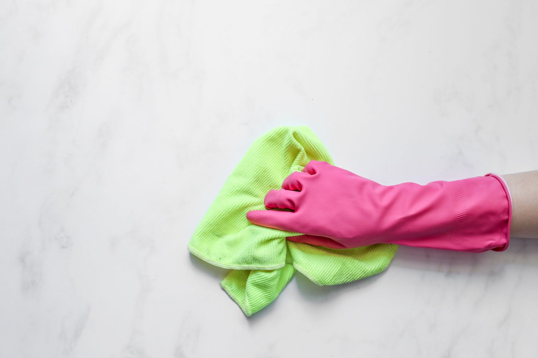 A gloved hand wiping an already-clean worktop