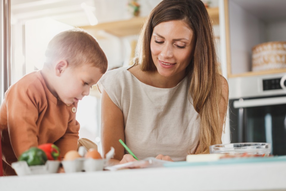 A parent and young child at a kitchen counter together