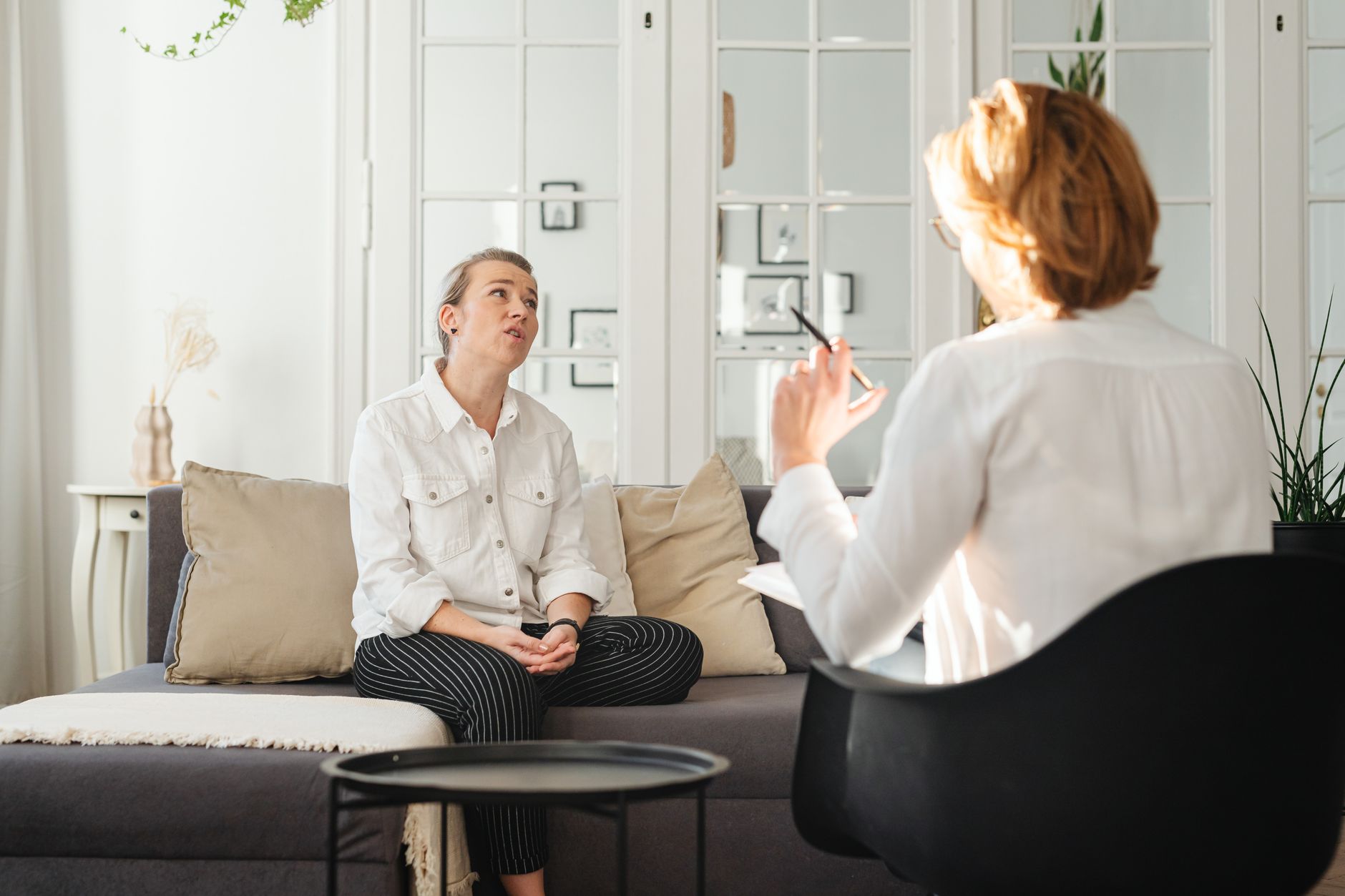 A psychiatrist listening to a patient in a consulting room