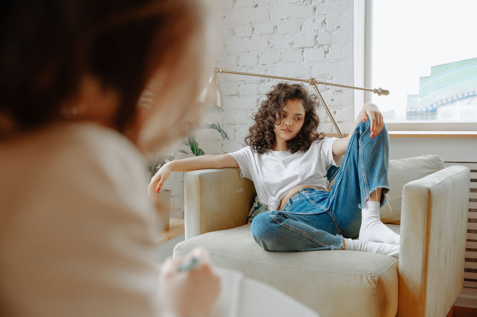 A young adult sitting with a therapist during a session